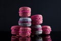 Sweet pink, violet french macaroon cookies on black background