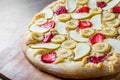 Sweet Pizza with Mozzarella cheese, apple, banana, strawberries. Fruit dessert pizza on wooden table Royalty Free Stock Photo