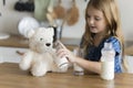 Sweet playful little child girl feeding teddy bear Royalty Free Stock Photo