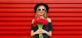 Sweet portrait of beautiful smiling woman with bouquet of red rose flowers in black round hat on background Royalty Free Stock Photo