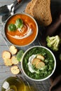 Sweet potato and broccoli cream soups on background, top view