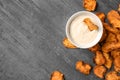 Sweet potato chips and bowl of sauce on grey background, top view. Royalty Free Stock Photo