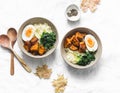 Sweet potato, couscous, spinach, egg buddha bowl on light background, top view. Vegetarian food Royalty Free Stock Photo