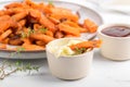 Sweet potato fries in a bowl with mayo sauce, homemade roasted pumpkin in the oven, close up Royalty Free Stock Photo