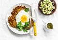Sweet potato rostis with fried egg and avocado salsa on light background, top view Royalty Free Stock Photo