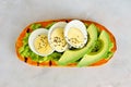 Sweet potato toast with avocado, eggs and chia seeds over marble