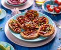 Sweet potato toast with beet hummus, grilled chickpeas, fresh parsley, nigella seeds and sunflower seeds on a plate on a blue ta Royalty Free Stock Photo