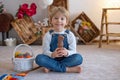 Sweet preschool boy in studio, playing with, egg for Easter and eating chocolate, child on Easter holiday Royalty Free Stock Photo