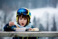 Sweet preschool child, eating soup in a restaurant on ski slope Royalty Free Stock Photo