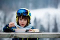 Sweet preschool child, eating soup in a restaurant on ski slope Royalty Free Stock Photo