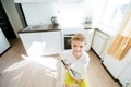 Sweet preschool child, helping his mom in the kitchen, making pancakes in the morning, happy childhood