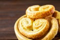 Sweet pretzels made of puff pastry in a bowl on a wooden table.