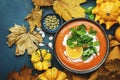 Sweet pumpkin soup puree with cream, orange and mint. Winter or autumn healthy vegetarian comfort slow food. Soup bowl on green