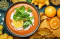 Sweet pumpkin soup puree with cream, orange and mint. Winter or autumn healthy vegetarian comfort slow food. Soup bowl on green