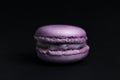 Sweet purple macaroon on black background