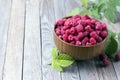 Sweet raspberries in bowl on wooden table. Close up, high resolution product