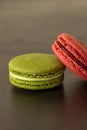 Sweet raspberries and pistachio macarons isolated on dark wood background. French pastry. Small delicious French cakes Royalty Free Stock Photo