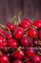 Sweet red cherries in glass bowl on dark wooden backgound with copy space. Summer and harvest concept. Vegan, vegetarian Royalty Free Stock Photo