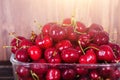 Sweet red cherries in glass bowl on dark wooden backgound with copy space. Sunny summer and harvest concept. Sunlight Royalty Free Stock Photo