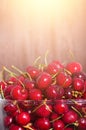 Sweet red cherries in glass bowl on dark wooden backgound with copy space. Sunny summer and harvest concept. Sunlight Royalty Free Stock Photo