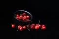 Sweet red cherries piled up in a black ceramic bowl on black background. Top view. Fruit Background. Selective focus Royalty Free Stock Photo