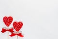 Sweet red lollipops hearts with ribbon on white wooden table as valentines day background.