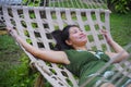 Sweet and relaxed Asian Chinese woman on her 20s wearing green Summer dress lying thoughtful pensive and comfortable in beautiful