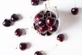 Sweet ripe cherries in glass bowl around white background. flat lay Royalty Free Stock Photo