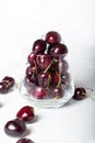 Sweet ripe cherries in glass bowl around white background Royalty Free Stock Photo