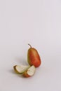 Sweet ripe fresh green cut pear with water drops, green leaves, spotted on white wood table