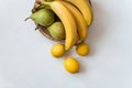 Sweet Ripe yellow bananas, pears and lemons on wooden plate on table. Isolated white background. Healthy tropical food Royalty Free Stock Photo