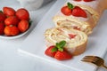 Sweet roll stuffed with strawberry and cream decorated with strawberries, powdered sugar and mint leaves Royalty Free Stock Photo