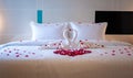 Swan towel decoration on bed with white pillow in bedroom interior
