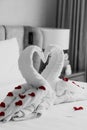 Sweet room in holiday, Swan towel decoration on bed with white pillow in bedroom interior.