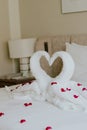 Sweet room in holiday, Swan towel decoration on bed with white pillow in bedroom interior.