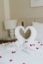 Sweet room in holiday, Swan towel decoration on bed with white pillow in bedroom interior.