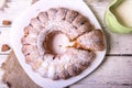 Sweet round fruity homemade pie with hole, on a white dish on a wooden table served with a cup of milk. Piece of cake