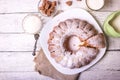 Sweet round fruity homemade pie with hole, on a white dish on a wooden table served with a cup of milk. Piece of cake