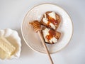 Sweet sandwiches with butter and honey on a white plate with a wooden spoon for honey