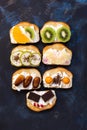 Sweet sandwiches with fruit. Toasts with cream and a variety of fruit-kiwi, orange, physalis, chocolate, pineapple, dates. Blue ab Royalty Free Stock Photo