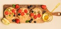 Sweet sandwiches peanut butter with fruits, berries with honey on a wooden board, top view. Royalty Free Stock Photo