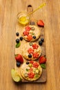 Sweet sandwiches peanut butter with fruits, berries with honey on a wooden board, top view. Royalty Free Stock Photo