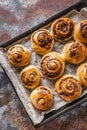 Sweet Scadinavian aromatic cinnamon rolls. Traditional homemade pastry made from butter dough. Delicious buns on baking paper.