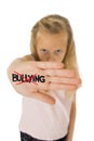 Sweet and scared little schoolgirl showing the word bullying scratched written in her hand