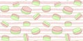 Sweet seamless pattern with pink and green macaroons on a soft striped background with dots