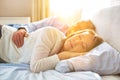 Sweet senior couple cuddling in bed with yellow lens flare in background