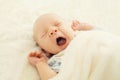 Sweet sleep infant lying and yawning on the bed