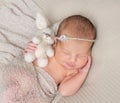 Sweet sleeping infant with toy in hand