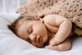 Portrait of sweet sleeping newborn baby in bed