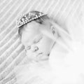 Sweet sleeping newborn baby girl with crown jewelry sleeping ona grey blanket Royalty Free Stock Photo